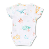 A white short-sleeve baby bodysuit featuring a colorful watercolor-style underwater print with a blue whale, orange octopus, green submarine, yellow submarine, jellyfish, and sea plants.