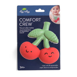 Green and red teething toy with smiling faces on a blue packaging labeled 'Comfort Crew' by itzy ritzy.
