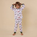 Child wearing pajamas with car pattern on a beige background
