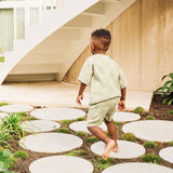 Child walking on stone path in garden