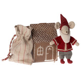 Small toy mouse in a red outfit with a house and bag on a white background