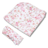 A baby gift set featuring a rectangular changing pad and a matching knotted headband, both printed with a pink flamingo and floral pattern on a white background.