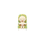 A small plush toy figure with a round beige face and limbs, seated in a yellow-and-green floral chair, centered on a plain white background.