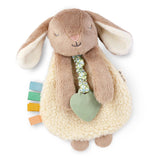 Plush bunny toy with teething ring and colorful tabs on a white background