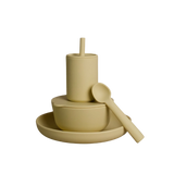 A matte, minimalist baby feeding set in a warm beige color, featuring a cup with a straw, a bowl, a spoon, and a plate, all photographed on a seamless white background.