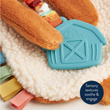 Toy with sensory textures and a barn design on a soft surface