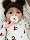 Baby wearing a black hat with ears, holding a white teething ring, and wrapped in a Mickey Mouse blanket.