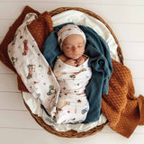 Newborn baby swaddled in a basket with patterned blankets