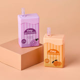 Two 'tiny tummies' juice boxes, one grape and one orange, on a beige background.