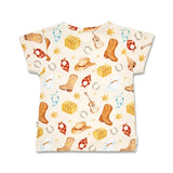 A short-sleeve baby t-shirt with a western-themed print on a cream background, featuring cowboy boots, hats, horseshoes, stars, and bandanas.