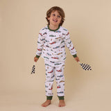 Child wearing car-themed pajamas on a beige background