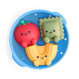 Colorful silicone food-shaped toys in a blue tray on a white background
