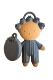 A matte, handcrafted clay figurine of a woman with grey rollers in her hair, holding a grey bomb-shaped accessory, isolated on a white background.