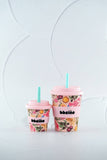 Two floral-patterned cups with pink lids and straws on a light gray background