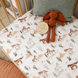 A fitted crib mattress with a western-themed horse print sheet, styled with a brown plush bunny toy and a round wooden tag that reads 'Happy through the night'.