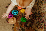 Baby playing with colorful toys on a patterned carpet