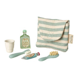 Set of children's bathroom items including a striped bag, cup, shampoo bottle, toothbrush, and toothpaste on a white background.