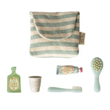 Set of children's dental care products including a striped pouch, bottle, cup, toothbrush, and brush with a visible brand logo on a white background.