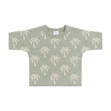 Green sweater with palm tree pattern on a white background