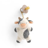 Plush cow toy with a pacifier on a white background