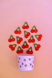 Pink cup with cherry design on a pink background