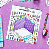 A sheet of Tinytown Pipstickers washi tape stickers displayed on a pink sprinkle-patterned background, surrounded by rolls of matching patterned tape.