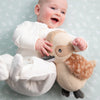 Baby holding a plush toy against a light gray background