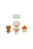 Set of small toys including a bear, a baby figure, and a cupcake on a white background