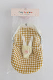Yellow gingham baby outfit with white suspenders in packaging on a light gray background