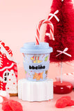 Children's cup with cartoon characters and 'bbeino' branding, decorated for Christmas with candy canes and red bows.