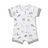 A baby short-sleeve zip-up romper in white, featuring an all-over print of dogs, trees, and grass, with sage green trim on the sleeves and leg cuffs.