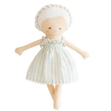 Doll with braided hair wearing a white dress with green stripes on a white background