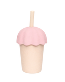 Pink ice cream-shaped cup with a straw on a white background