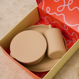 Set of beige ceramic items in an open box with a red interior