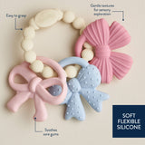Set of soft silicone teething toys with text describing features on a beige background