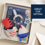 Colorful baby teething ring set in a box with packaging labeled 'Bitzy Busy Ring'.