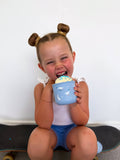 Child holding a blue cup with a white background