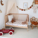Nursery room with wooden crib, toys, and decorative elements.