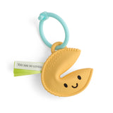 Yellow crescent moon-shaped teething toy with a green tag on a white background