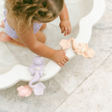Child playing with mermaid toys in a bathtub