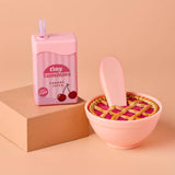 Pink cherry juice box and pie-shaped container on a beige background