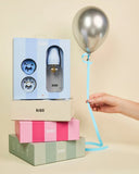 BIBS baby bottle packaging with a hand holding a balloon against a beige background