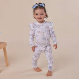 Child wearing a floral onesie on a beige background