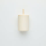 White cylindrical lamp with wooden fixture on a light gray background