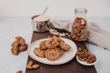Plate of cookies with ingredients like almonds and figs on a wooden board.