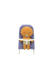 A plush teddy bear toy with an orange body and a blue-and-white gingham patterned headrest, seated in a high chair with a white harness strap across its torso, isolated on a white background.