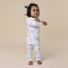 Child wearing a floral onesie on a beige background