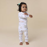 Child wearing a floral onesie on a beige background