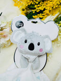 Plush koala toy with a 'Onya Kids' tag on a floral background