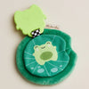 Green plush toy with a frog design on a beige background